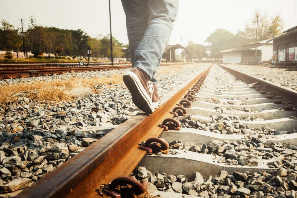 girl walking on rail of railway - everything is hard